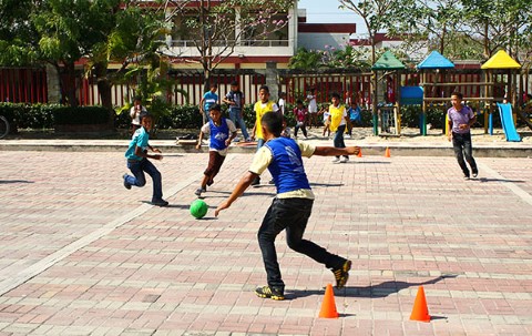 Kids participate in a Sports for Development game at the expansive community center outdoor court  