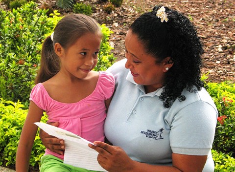 La voluntaria Pilar Ayala lea una carta a una niña en Guayaquil.