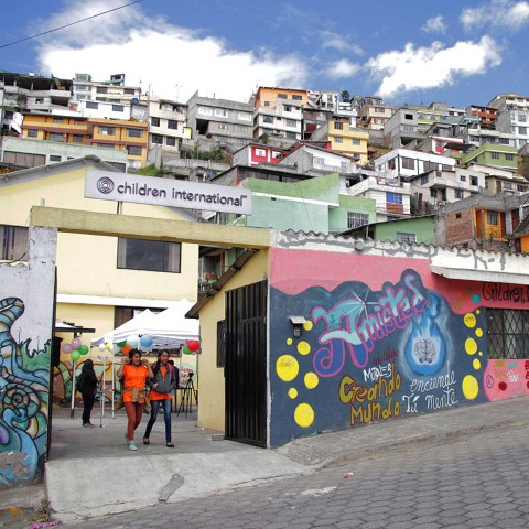 un grupo de personas caminando frente a un edificio colorido