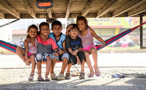 a group of children sitting in a hammock