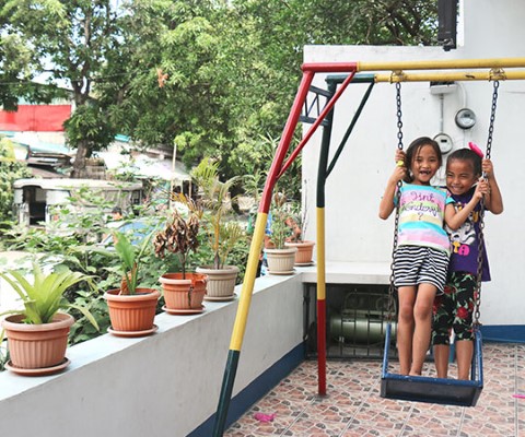 dos niñas juegan en un columpio