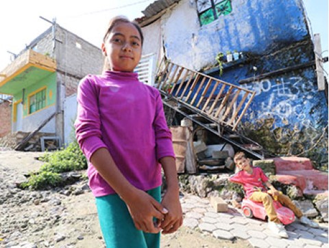 a young girl standing in front of a house