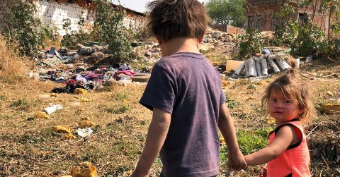 un par de niños tomados de la mano en un campo