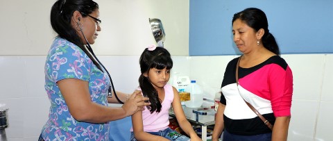 una mujer parada junto a una niña en una habitación