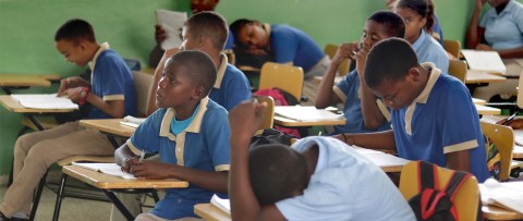 a group of children sitting at desks in a classroom