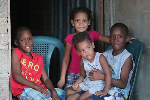 a group of children sitting on top of a blue chair