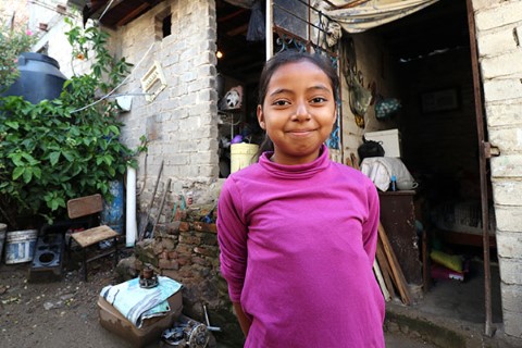 a young girl standing in front of a building