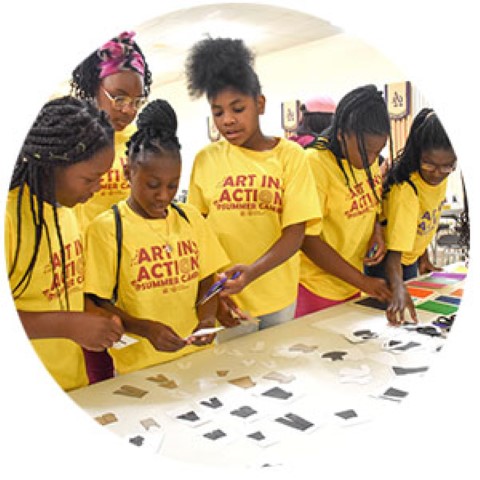 a group of young girls standing around a table