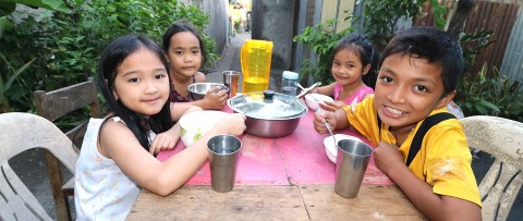 un grupo de niños pequeños sentados en una mesa