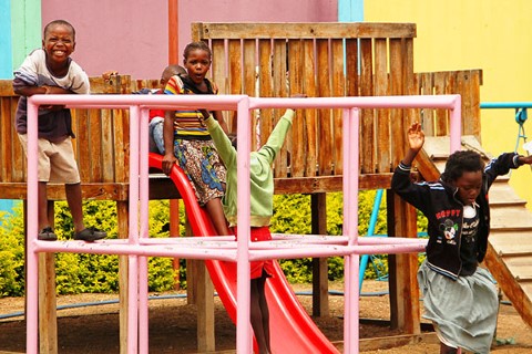 Niños africanos se divierten en un patio de recreo al aire libre