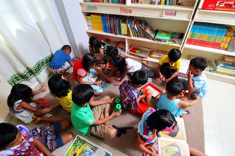 A group of kids gather for games and reading in a Philippines community center