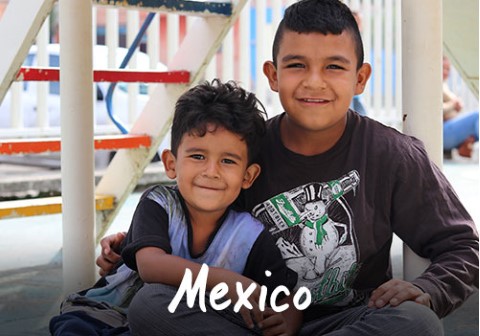 Mexico | two young boys sitting on the ground next to each other