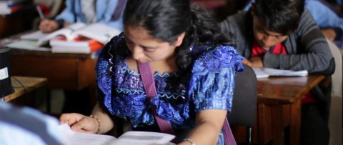 una mujer sentada en un escritorio con un libro