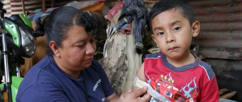 una mujer evalúa la salud de un niño con la cinta MUAC de C