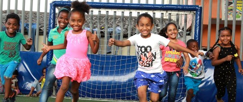 a group of young children playing a game of soccer