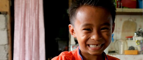 A young boy’s smile reveals a missing front tooth