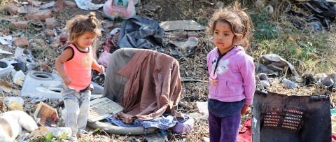 dos niñas paradas junto a un montón de basura