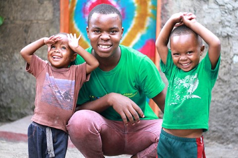 a man kneeling down with two small children