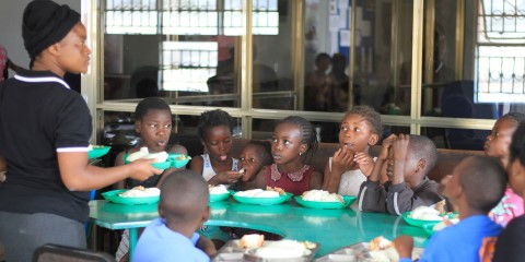 un grupo de niños sentados alrededor de una mesa comiendo