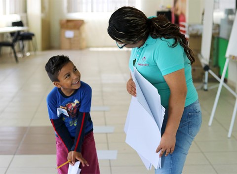 Un niño sonríe mientras habla con un instructor.