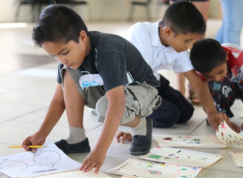 Un grupo de niños dibuja y escribe.