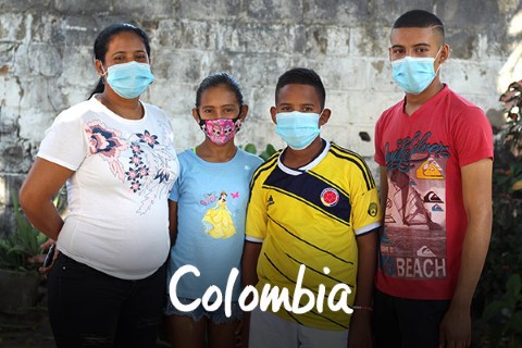 Colombia | a group of people wearing face masks in front of a wall