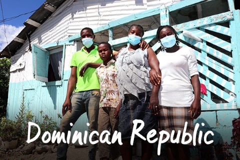 Dominican Republic | a group of people standing in front of a house