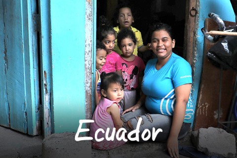 Ecuador | una mujer sentada en una puerta con un grupo de niños