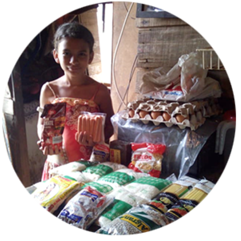 a little girl standing in front of a table full of food