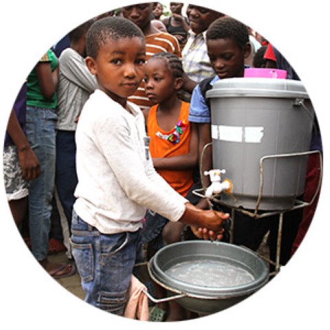 a group of people standing around a metal bucket