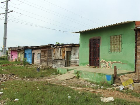 a row of shacks on a dirt road