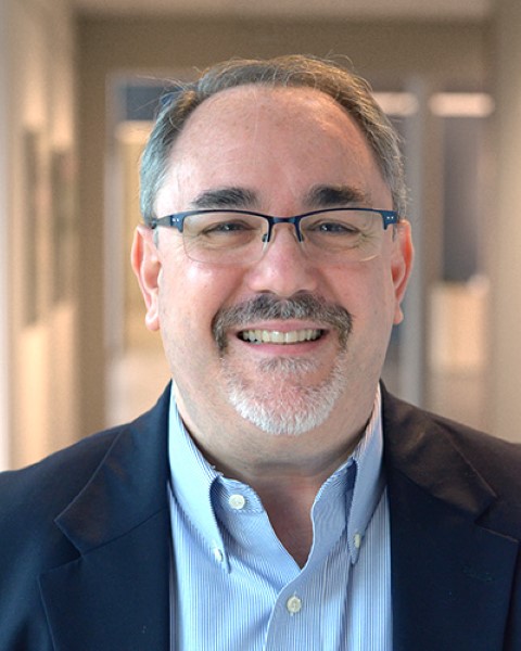 a man wearing glasses and a suit jacket