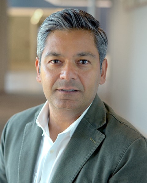 un hombre con una chaqueta gris y camisa blanca