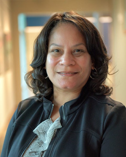 a woman standing in a hallway with a smile on her face