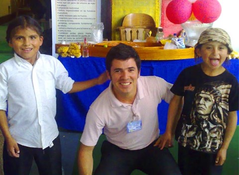 Carlos poses with two Ecuadorian kids at a food festival