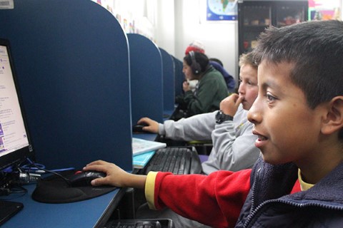 a young boy sitting in front of a computer