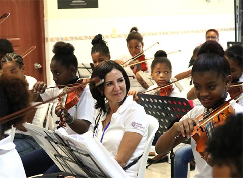 Maria Fernanda observes youth play in the Youth Orchestra