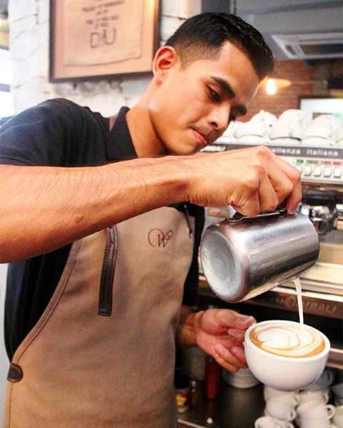 Melvin shows off the cappuccino he made at work