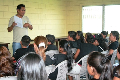 Un miembro del personal de Children International habla con un grupo de jóvenes en el centro comunitario