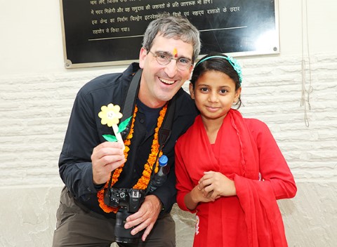 Laird Malamed, contribuyente de Children International, y una niña sonríen para la cámara.