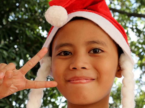 Una niña con una gorra de Santa Claus celebra la Navidad, el feriado más largo de las Filipinas.