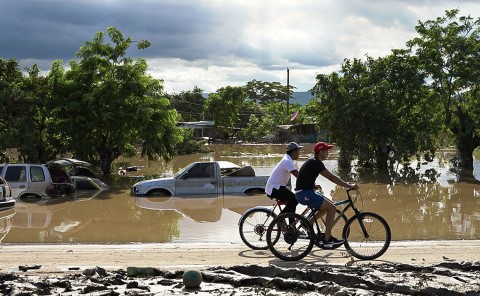 a man riding a bike through a flooded street