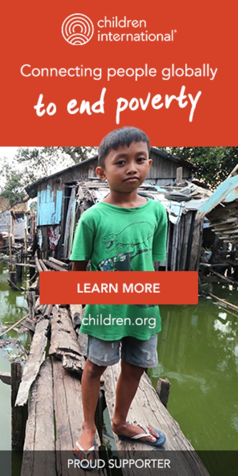 a young boy standing on a wooden bridge