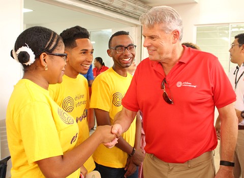 Dave Cormack shakes hands with a Children International teen