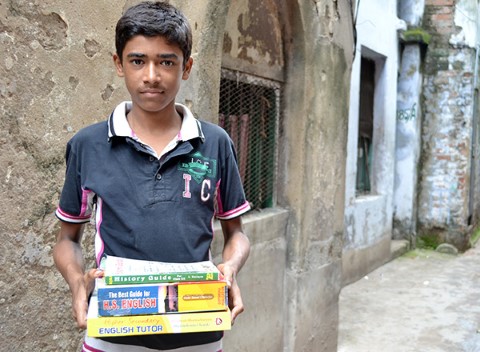 A HOPE scholar recipient in India carries his textbooks.   