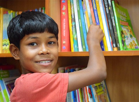 Niño intenta agarrar un libro