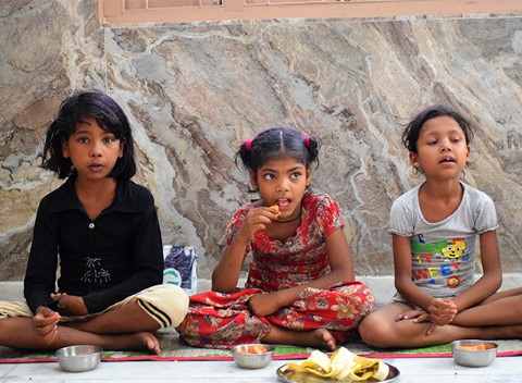Tres niñas reciben fruta como parte del programa de nutrición.