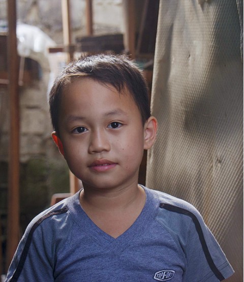 Portrait of 7-year-old Justine at his family's home in Manila, Philippines