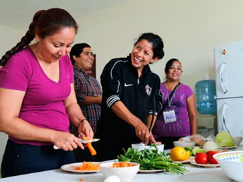 Mamás en México reciben instrucciones para preparar verduras.