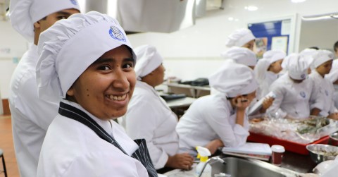 a group of chefs in a kitchen preparing food